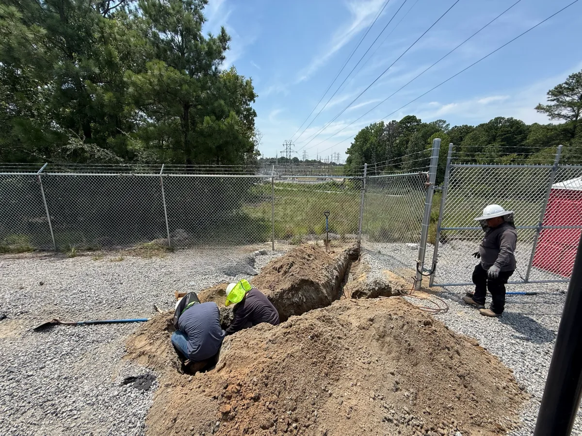 Crew digging a trench by hand